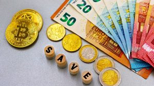 Euro banknotes and Bitcoin coins arranged with 'save' text for finance concept.